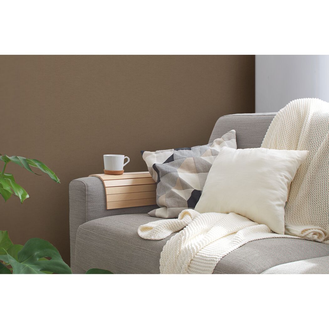 Sofa mit Kissen, Decke und einem Beistelltisch mit Tasse