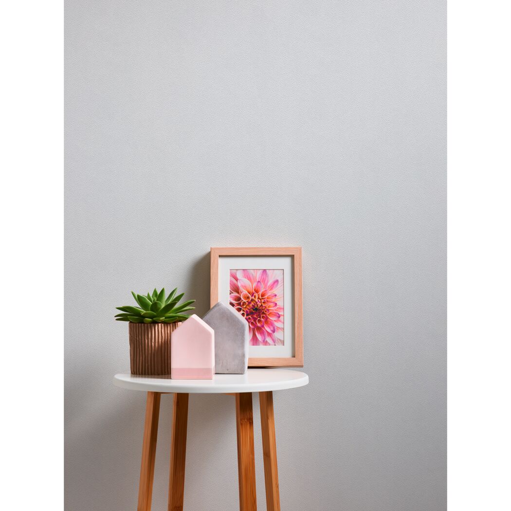 Beistelltisch mit Pflanze, Deko-Häusern und gerahmtem Bild