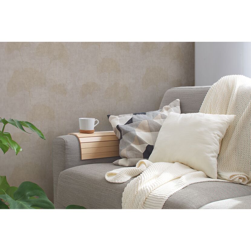 Gemütliches Sofa mit Kissen, Decke und Beistelltisch.