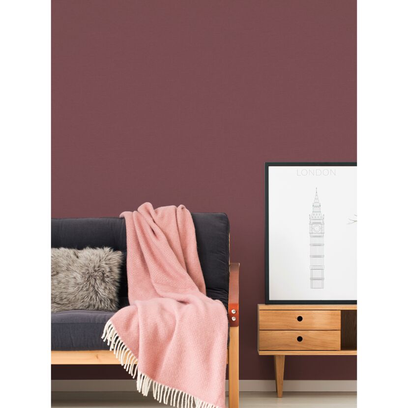 Sofa mit rosa Decke und London-Poster an Wand
