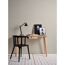 Schreibtisch mit Lampe und Bildern vor beiger Wand