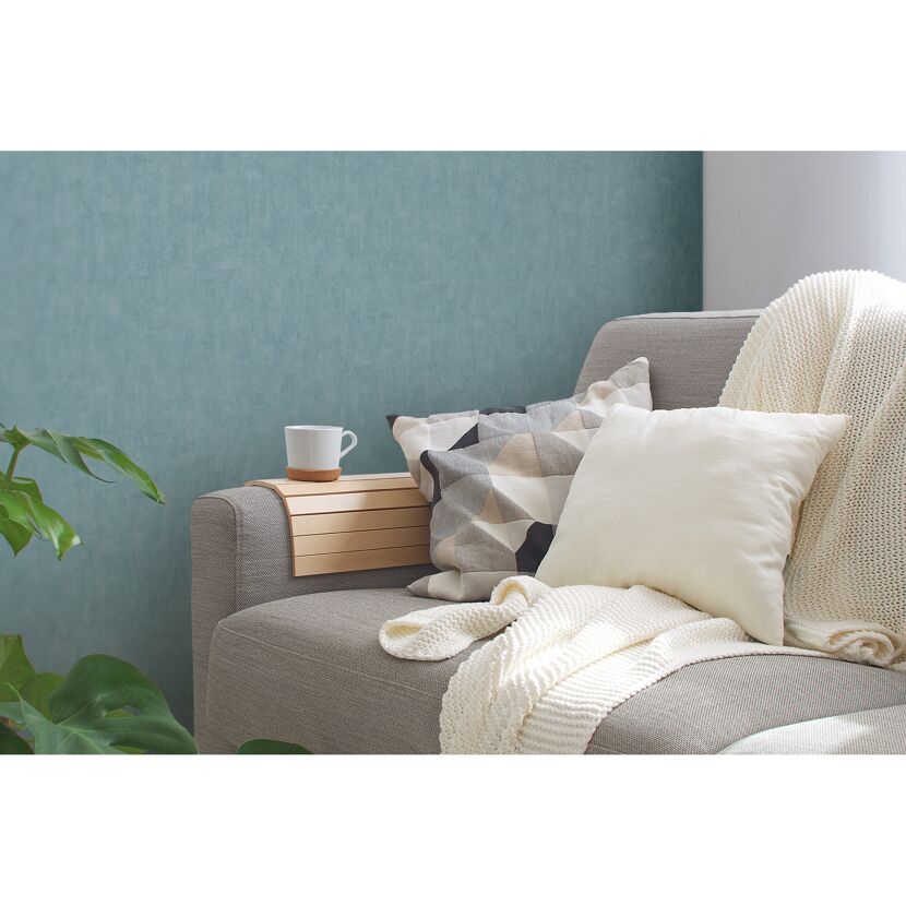 Sofa mit Kissen, Decke und Tablett mit Tasse