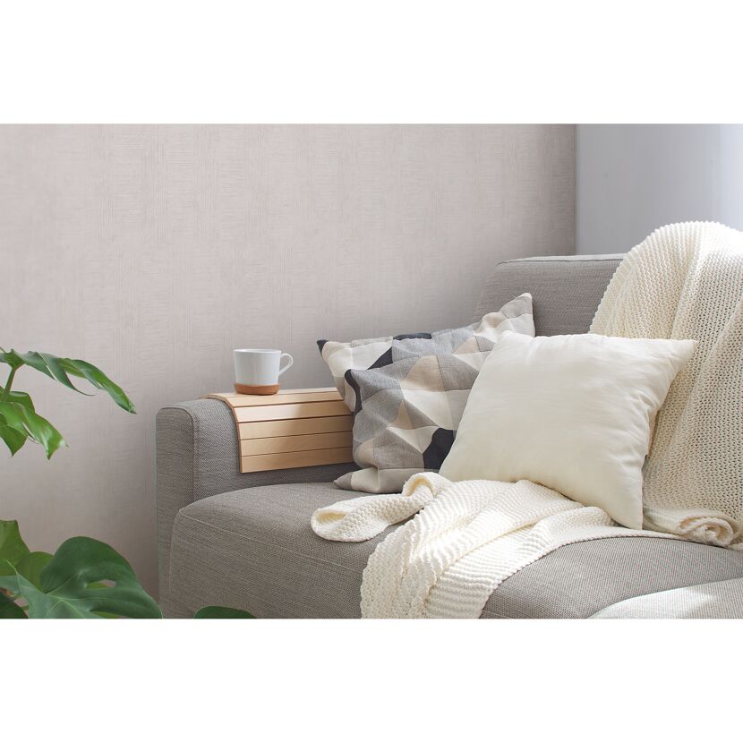 Gemütliches Wohnzimmer mit beiger Tapete und grauer Couch