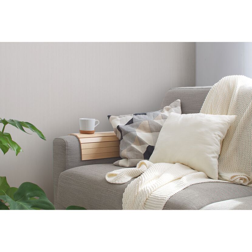 Graues Sofa mit Kissen, Decke und Tablett