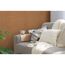 Sofa mit Kissen und Decke vor brauner Wand