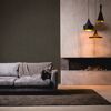 Wohnzimmer mit braunem Sofa, Kamin und drei Hängelampen