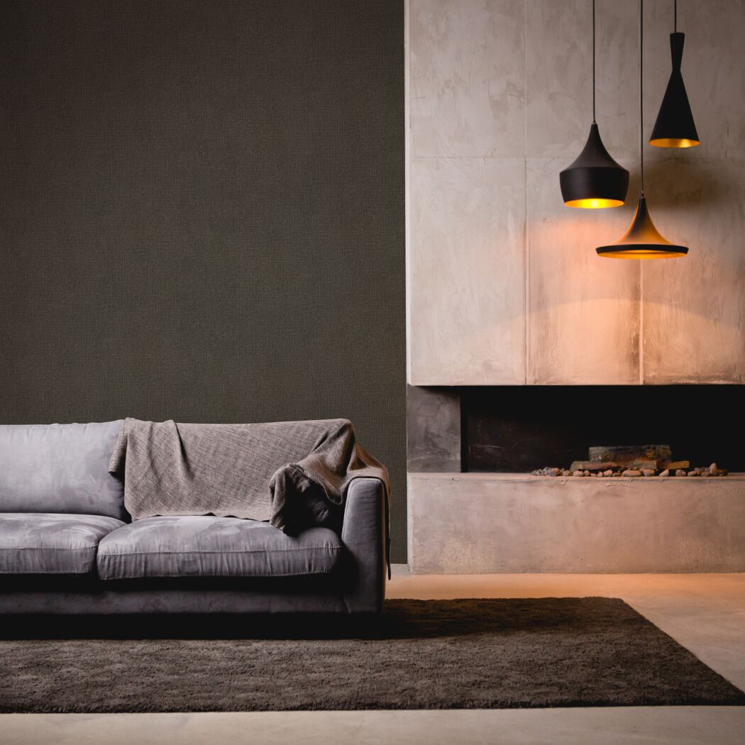 Wohnzimmer mit braunem Sofa, Kamin und drei Hängelampen