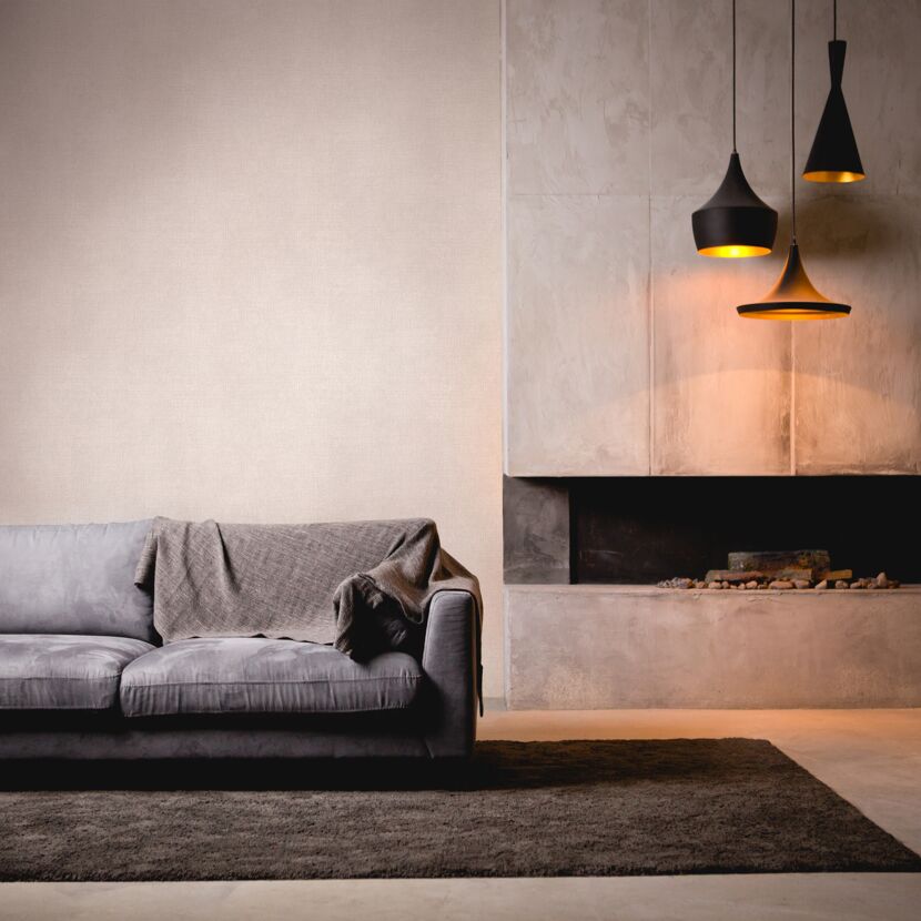 Wohnzimmer mit Sofa, Kamin und drei Hängelampen