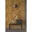 Konsolentisch mit goldener Vase und Spiegel vor goldener Wabenwand.