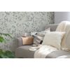Gemütliches Wohnzimmer mit Blumentapete und beiger Couch