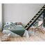 Schlafzimmer mit Bett, Korbstuhl und Holztreppe