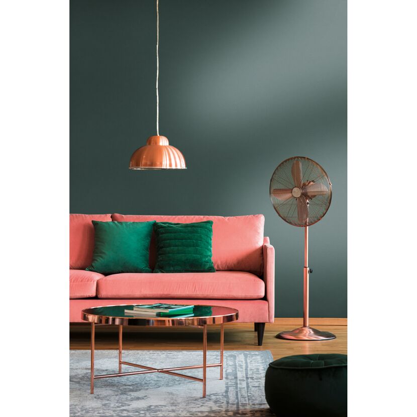 Wohnzimmer mit rosafarbenem Sofa, Ventilator und kupferfarbenen Akzenten