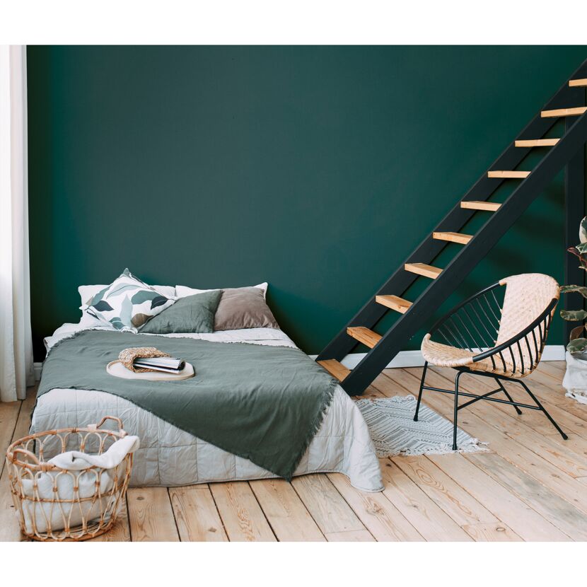 Schlafzimmer mit petrolfarbener Wand und Holztreppe