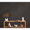 Holzregal mit Deko vor schwarzer Wand