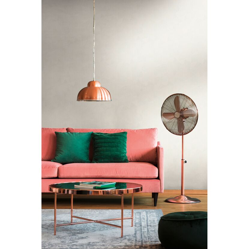 Wohnzimmer mit rosa Sofa, Ventilator und kupferfarbenem Tisch