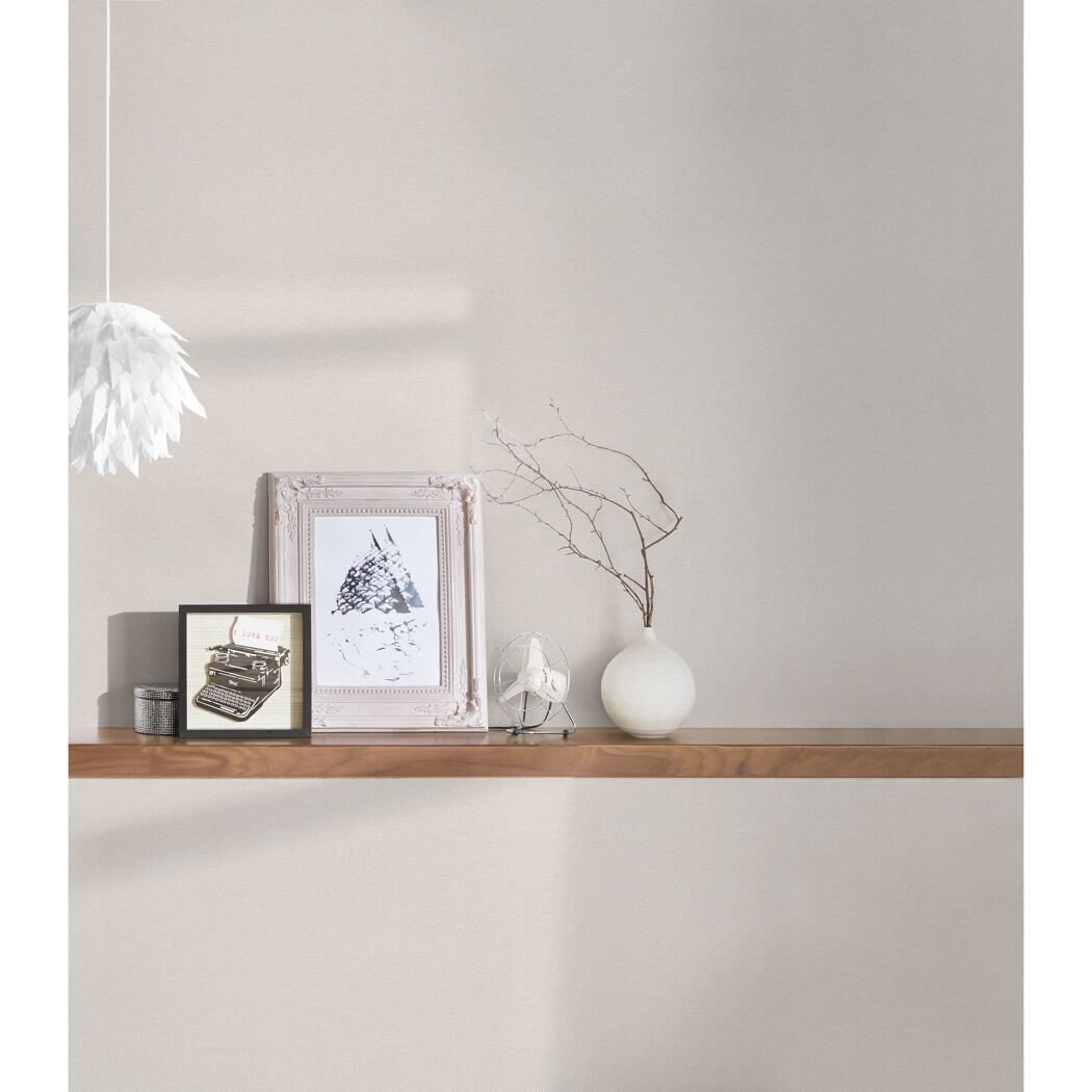 Beige Vliestapete an der Wand. Dekoration auf einem Wandboard.