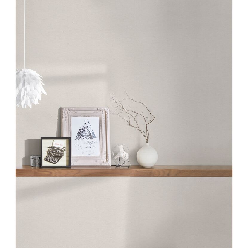 Beige Vliestapete an der Wand. Dekoration auf einem Wandboard.