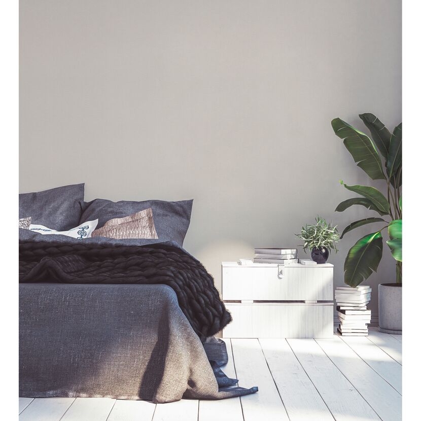 Gemütliches Schlafzimmer mit Bett, Nachttisch und Pflanze