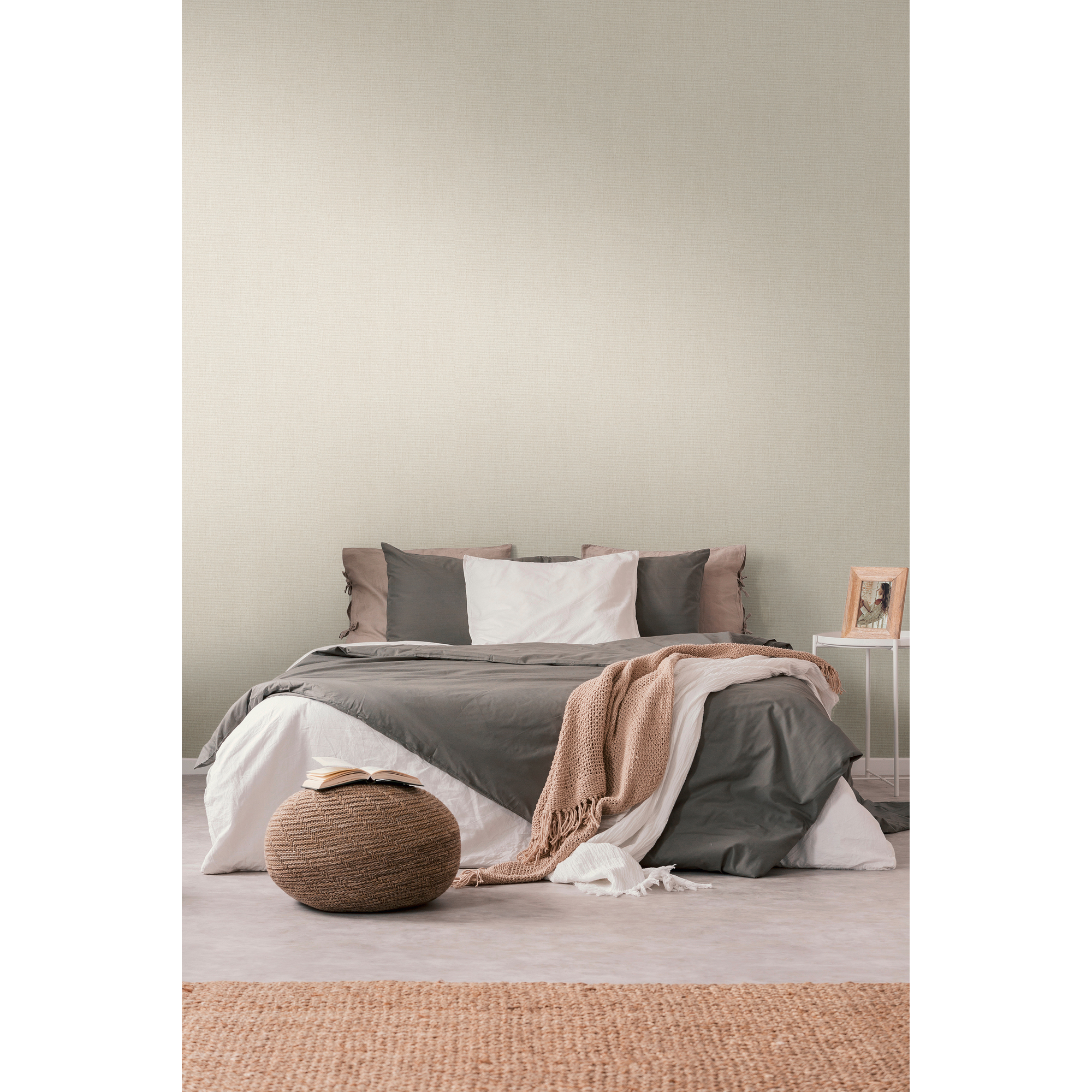 Gemachtes Bett mit beigefarbener Tapete