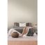 Gemachtes Bett mit beigefarbener Tapete