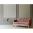 Rosa Sofa vor gemusterter Tapete