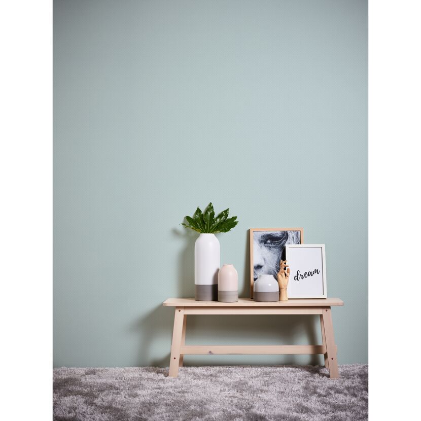 Bank mit Deko vor gepunkteter Wand