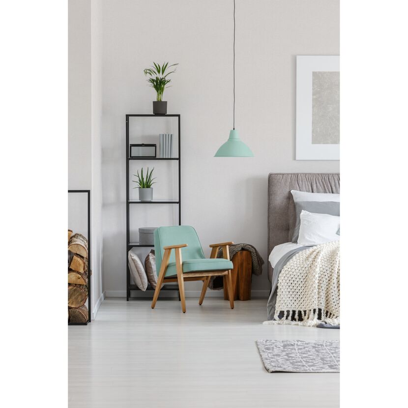 Helles Schlafzimmer mit türkisem Sessel