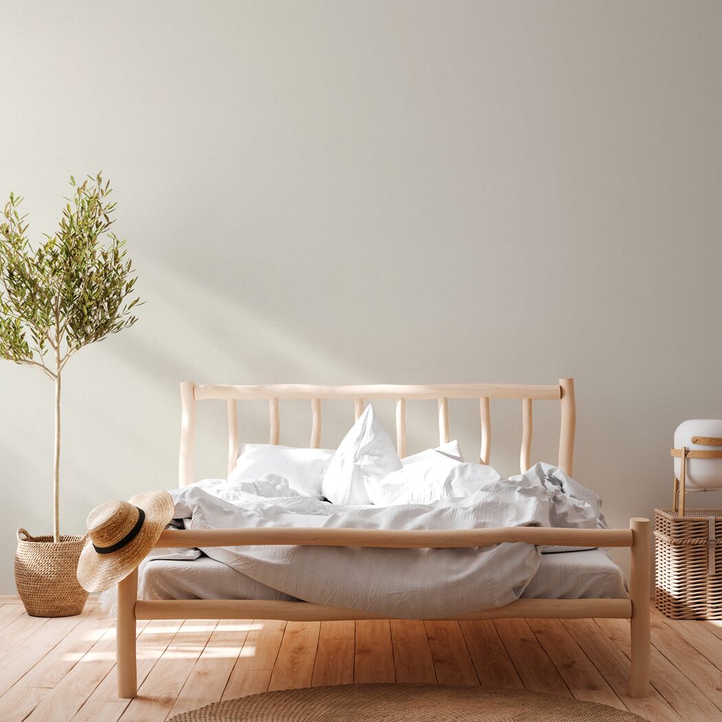 Helles Schlafzimmer mit Bett und Pflanze