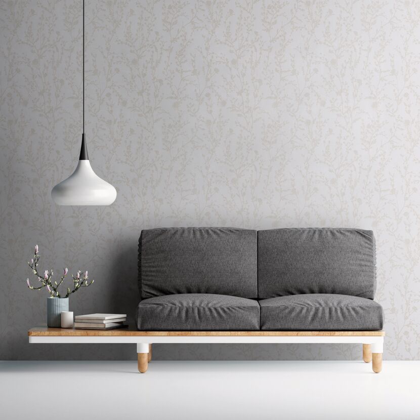 Graues Sofa vor Wand mit floralem Muster