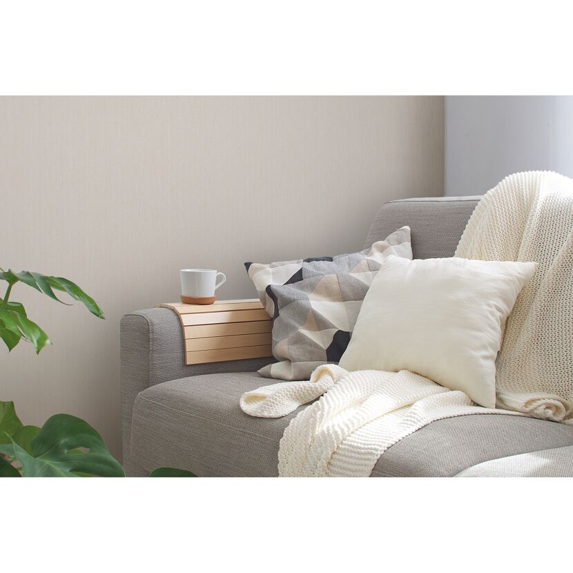 Beiges Sofa mit Kissen und Decke