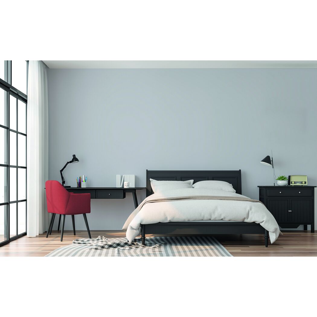 Schlafzimmer mit Bett, Schreibtisch und rotem Stuhl