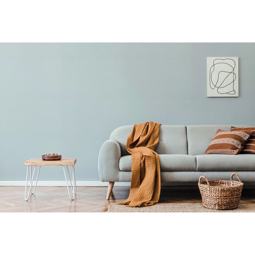 Gemütliches Wohnzimmer mit grauem Sofa, Beistelltisch und Deko