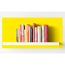 Bücherregal mit Kochbüchern vor gelber Wand