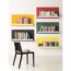 Bunte Wand mit weißen Bücherregalen