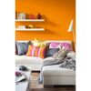 Wohnzimmer mit orangener Wand und weißer Couch