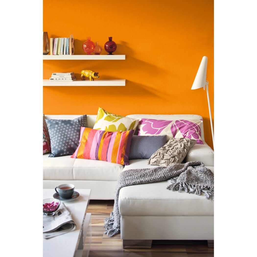 Wohnzimmer mit orangener Wand und weißer Couch