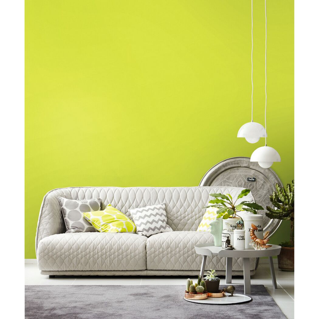 Wohnzimmer mit hellgrüner Wand und weißem Sofa