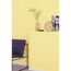 Gelbe Wand mit Dekoelementen und Sessel