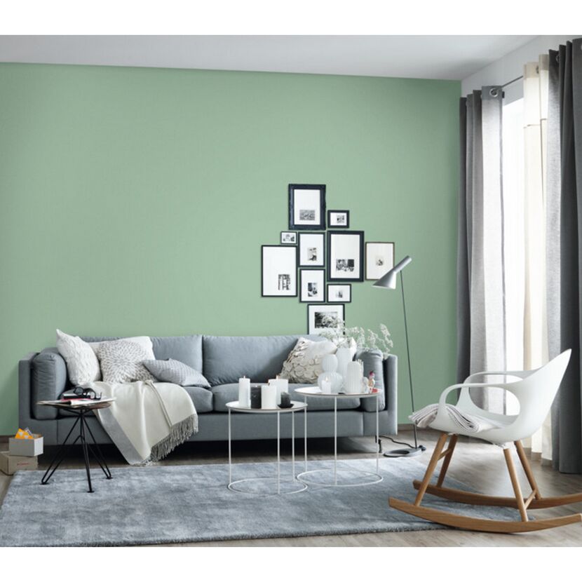 Wohnzimmer mit mintgrüner Wand und grauer Couch