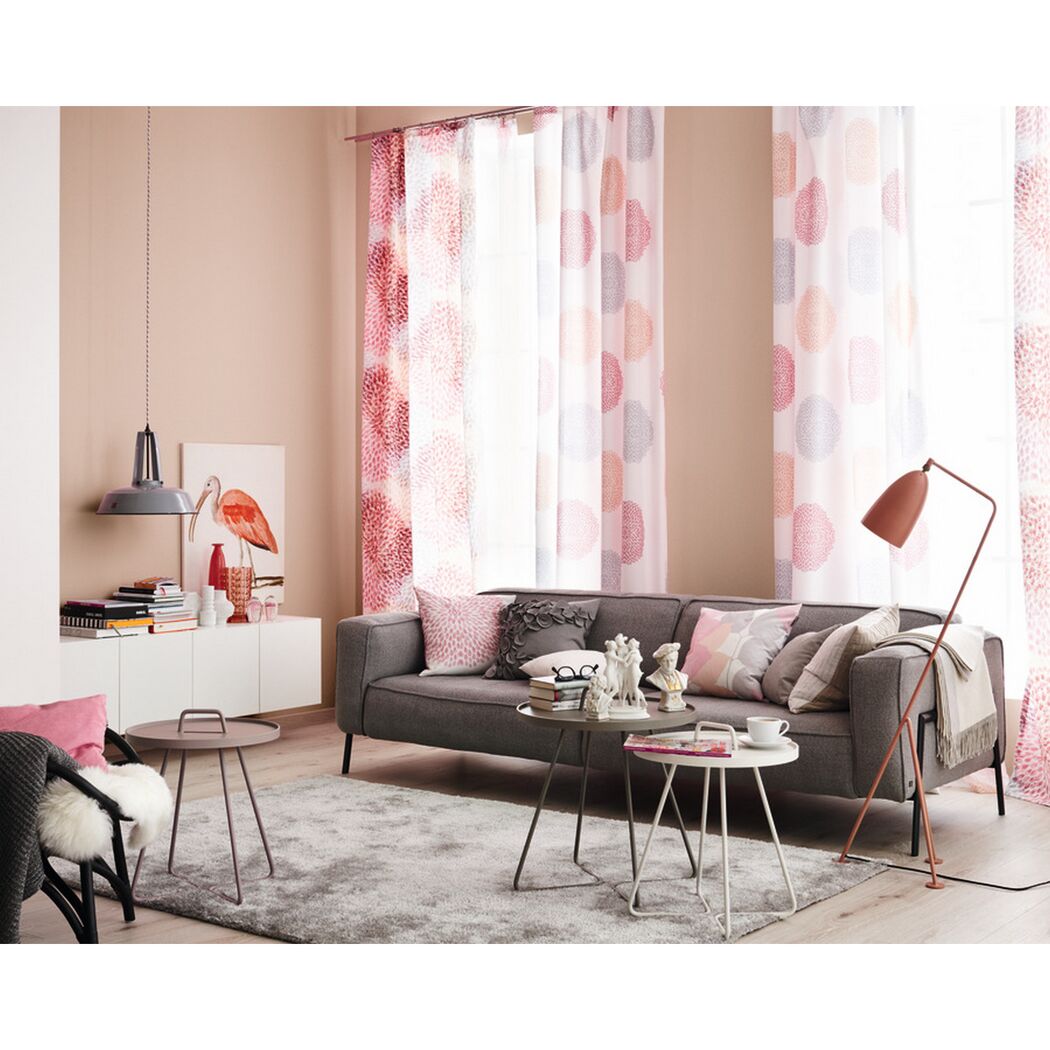 Wohnzimmer mit Sofa, Vorhängen und Deko in Rosa- und Rottönen