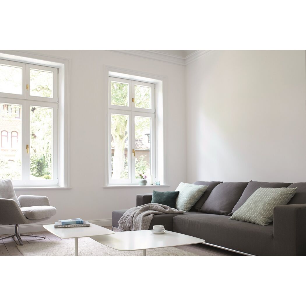 Modern eingerichtetes Wohnzimmer mit Sofa und Sessel