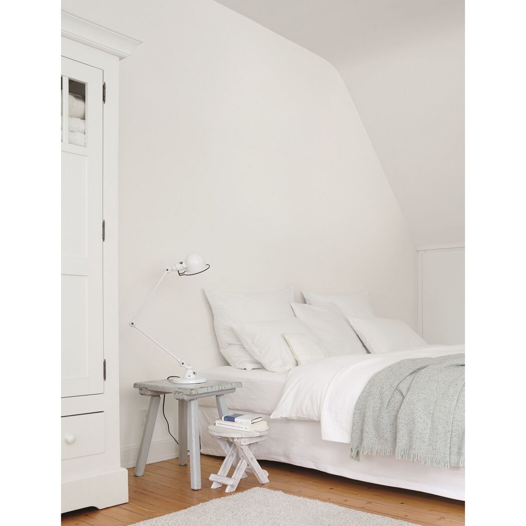 Helles Schlafzimmer mit weißem Bett und weißem Schrank