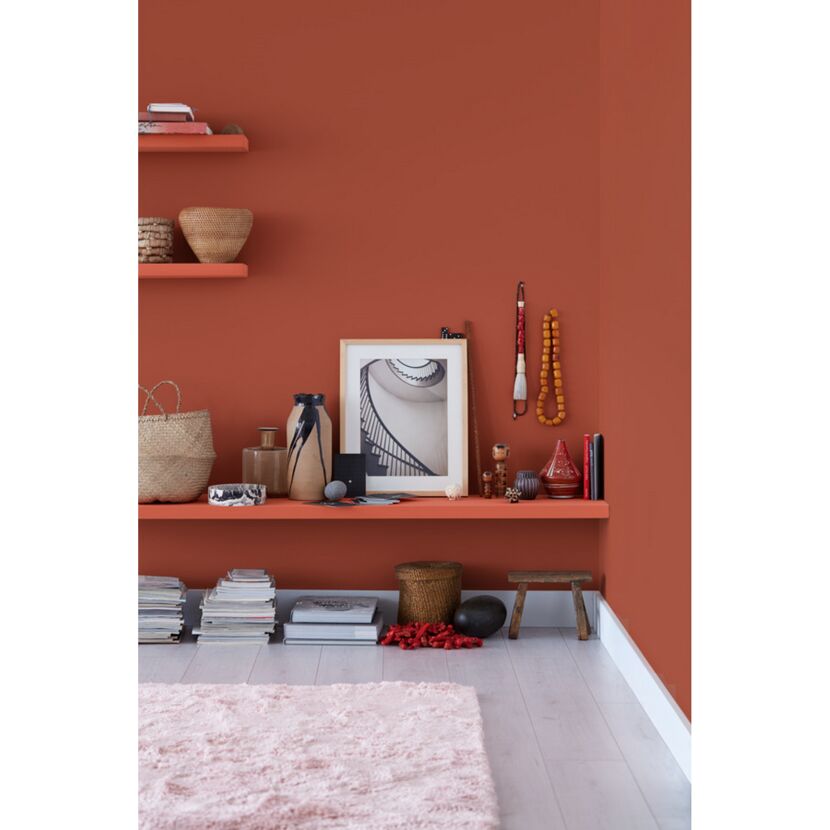 Wand in Terracotta-Ton mit Dekorationen auf einem Wandboard.