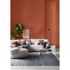 Wohnzimmer mit terracottafarbener Wand und hellem Sofa