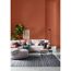 Wohnzimmer mit terracottafarbener Wand und hellem Sofa