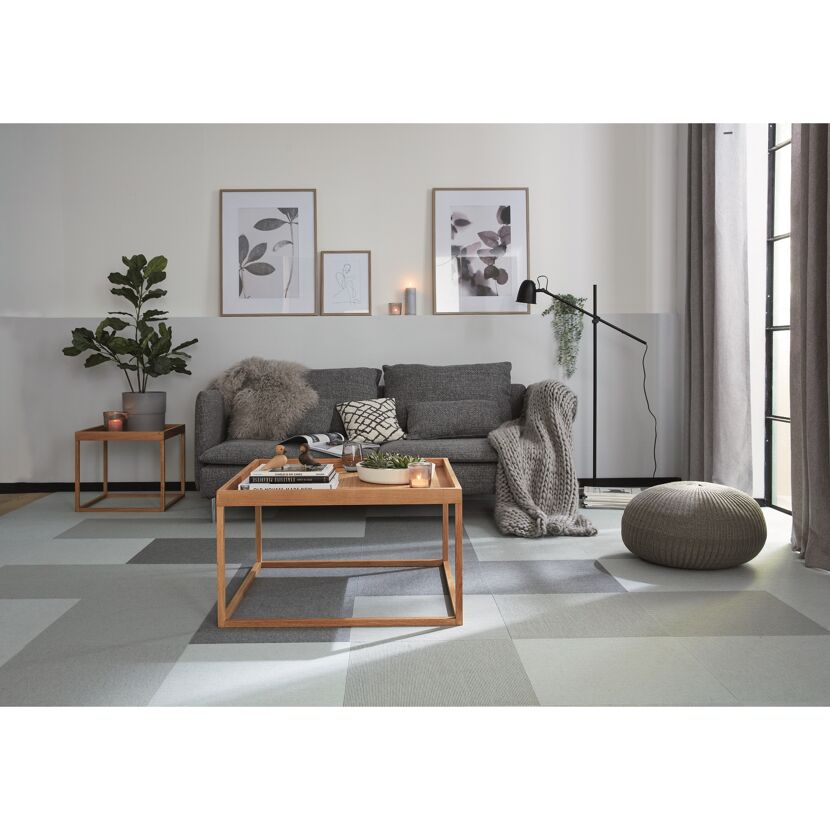 Wohnzimmer mit grauem Sofa, Couchtisch und Teppich