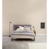 Modernes Schlafzimmer mit weißem Bett und grauer Wand.