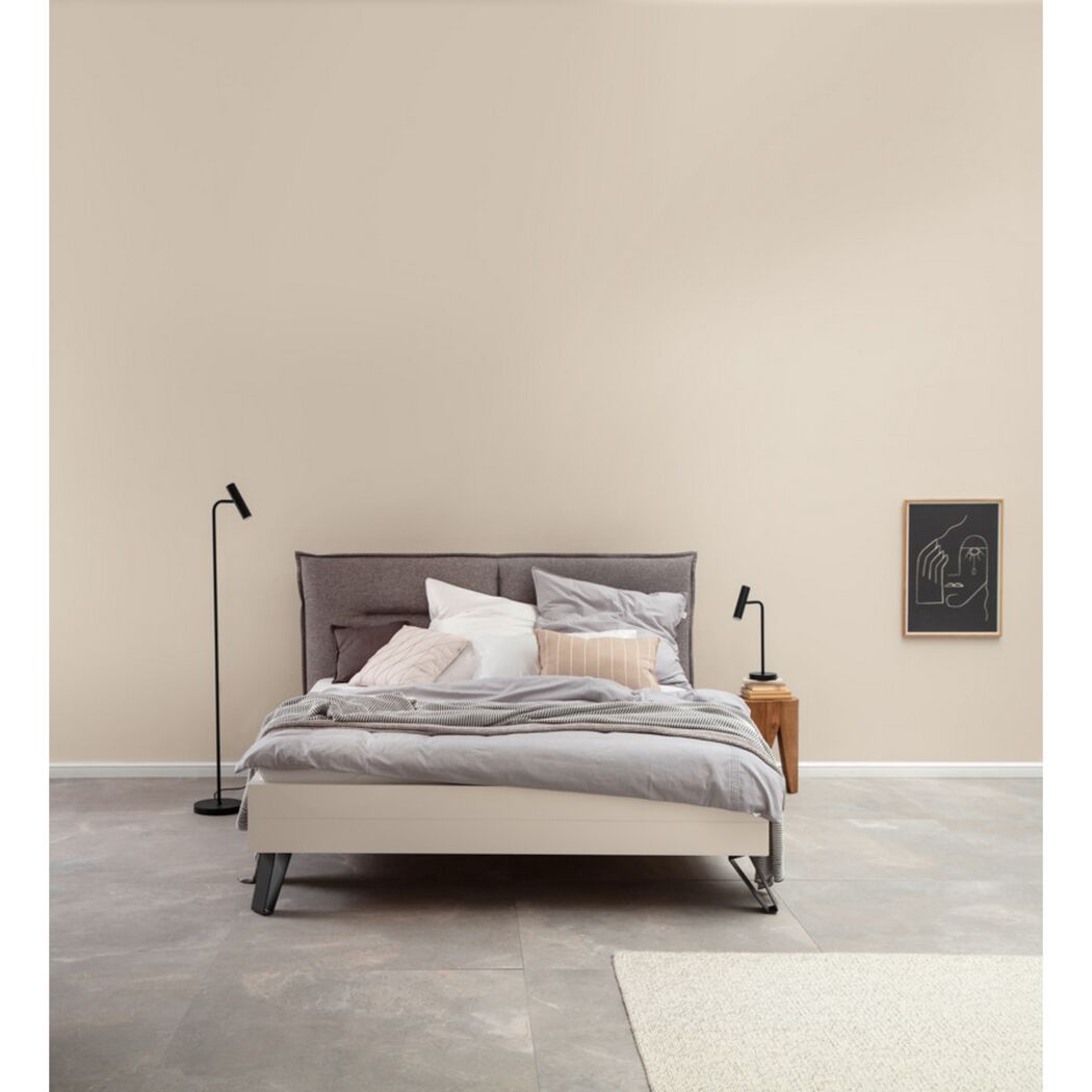 Modernes Schlafzimmer mit weißem Bett und grauer Wand.