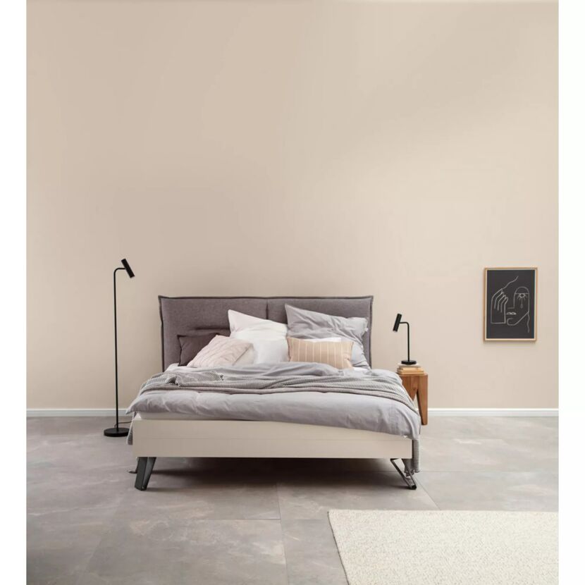 Modernes Schlafzimmer mit weißem Bett und grauer Wand