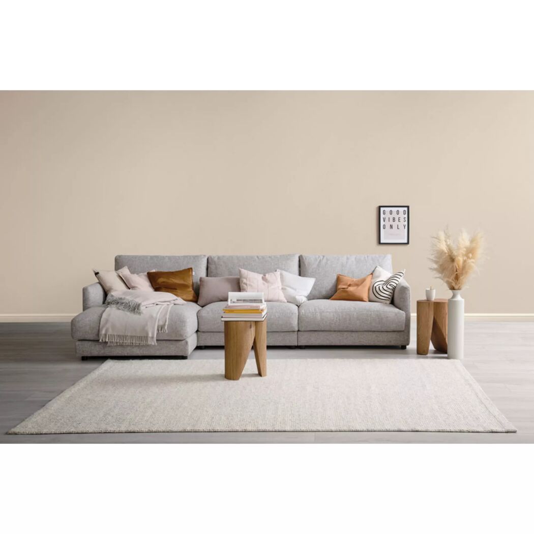 Graues Ecksofa mit Dekokissen und Behocker